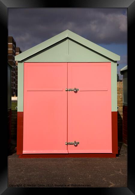 Peach colour beach hut against stormy sky Framed Print by Gordon Dixon