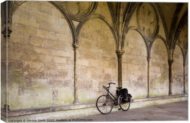 A priest's bicycle leaning up against a wall in the Cloister's Courtyard of Salisbury Cathedral, Wiltshire Canvas Print by Gordon Dixon