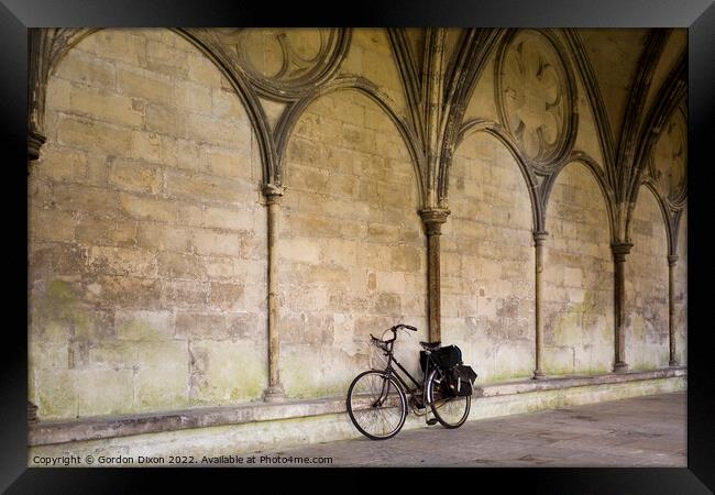 A priest's bicycle leaning up against a wall in the Cloister's Courtyard of Salisbury Cathedral, Wiltshire Framed Print by Gordon Dixon