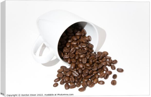Roasted coffee beans spilling out of a mug - white background Canvas Print by Gordon Dixon