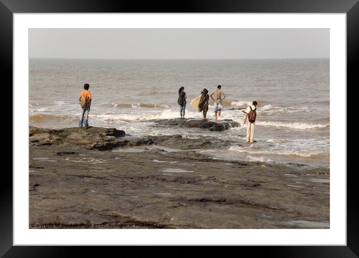 Group of Indian students stand on rocks at Mumbai as the tide comes in Framed Mounted Print by Gordon Dixon