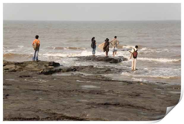 Group of Indian students stand on rocks at Mumbai as the tide comes in Print by Gordon Dixon