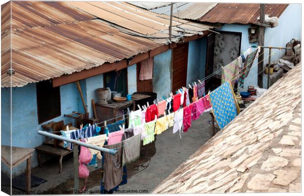Bright colours in the laundry drying at a shanty town in Accra, Ghana Canvas Print by Gordon Dixon