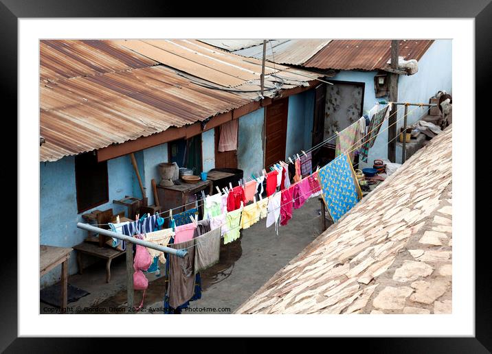 Bright colours in the laundry drying at a shanty town in Accra, Ghana Framed Mounted Print by Gordon Dixon