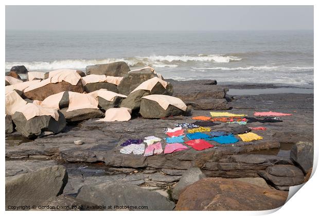 Freshly laundered clothes and fabrics drying on rocks by the sea at Mumbai, India Print by Gordon Dixon