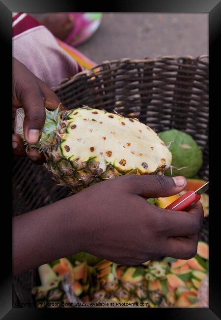 Preparing a pineapple for eating - roadside seller, Ghana Framed Print by Gordon Dixon
