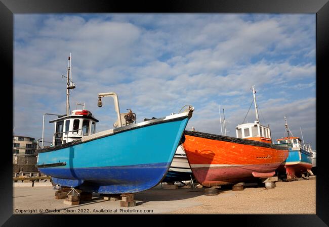 Orange and blue fishing trawlers on quay in winter Framed Print by Gordon Dixon