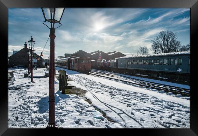 Locomotives on a snow-covered station platform Framed Print by Stuart Chard