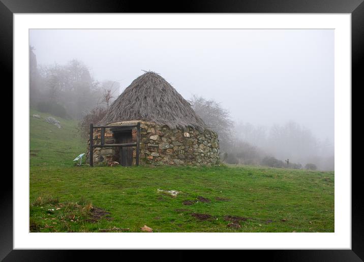 old circular stone house with thatched roof in the mountains Framed Mounted Print by David Galindo