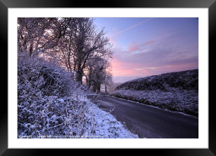 A quiet country road on a snowy morning with a colourful sinrise Framed Mounted Print by Angela Redrupp
