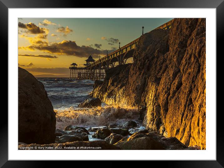 Clevedon Pier with sunlight reflecting onto the rocks Framed Mounted Print by Rory Hailes