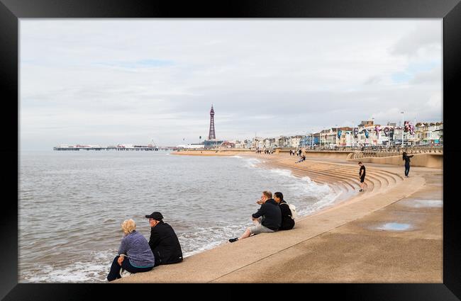 Tourists sit on Blackpool seafront Framed Print by Jason Wells