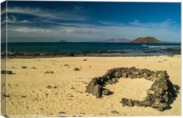 Rock beach shelter on Fuerteventura. In the distan Canvas Print by Michael Shannon