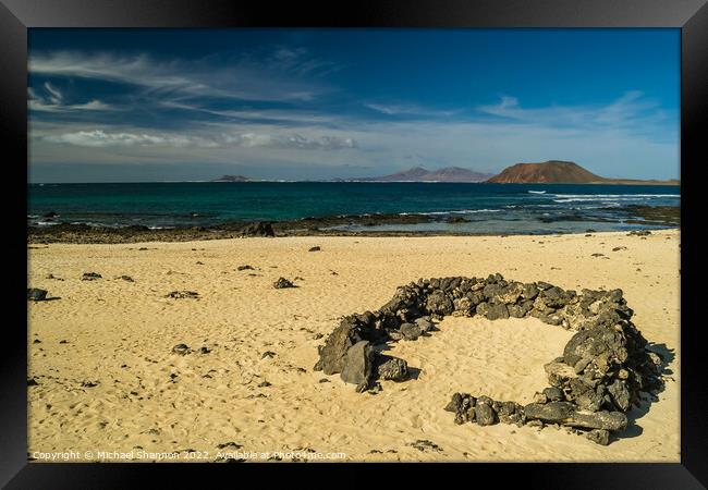 Rock beach shelter on Fuerteventura. In the distan Framed Print by Michael Shannon