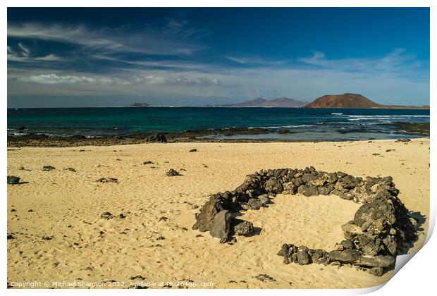 Rock beach shelter on Fuerteventura. In the distan Print by Michael Shannon