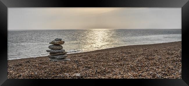 Tranquil beach with stone sculpture and sun on water - Dorset Framed Print by Gordon Dixon