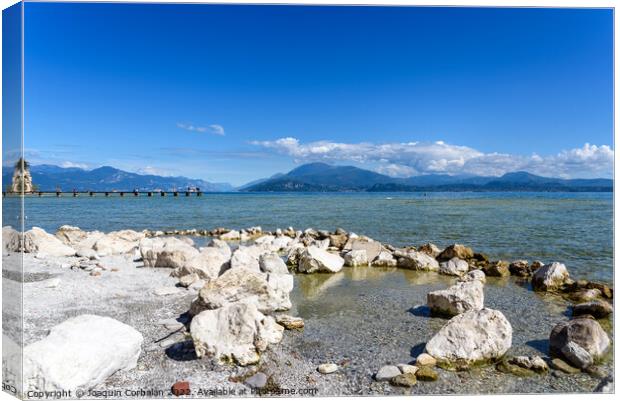 Calm water lake in Garda, Italy with a wooden walkway on a sunny Canvas Print by Joaquin Corbalan