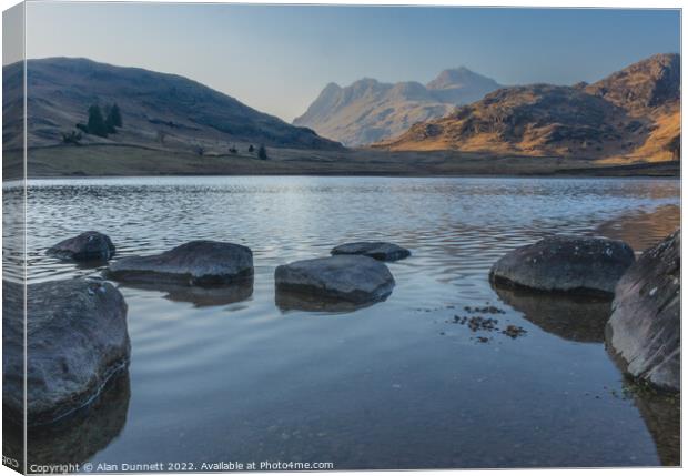 Blea Tarn as the sun sets on the Langdales Canvas Print by Alan Dunnett