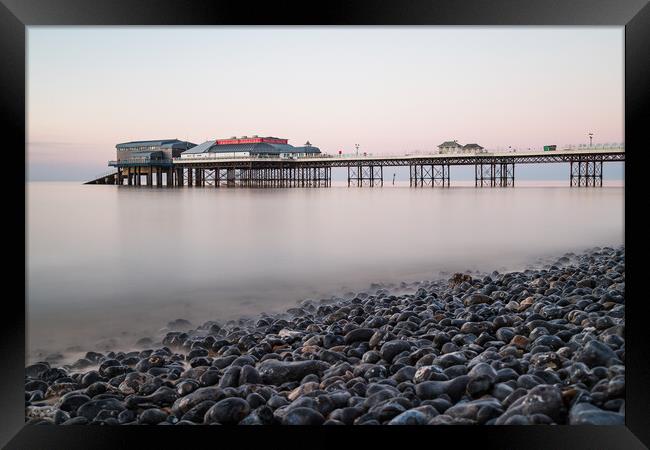 Cromer pier seen over the pebble beach Framed Print by Jason Wells
