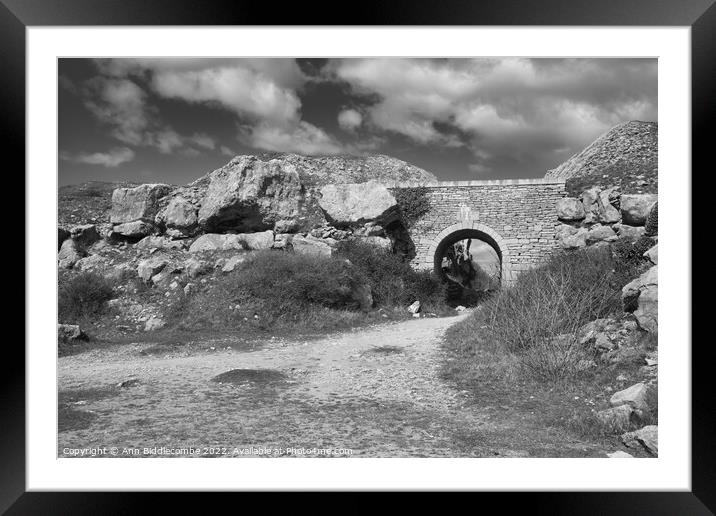 Stone archway at Portland Quarry in black and white Framed Mounted Print by Ann Biddlecombe