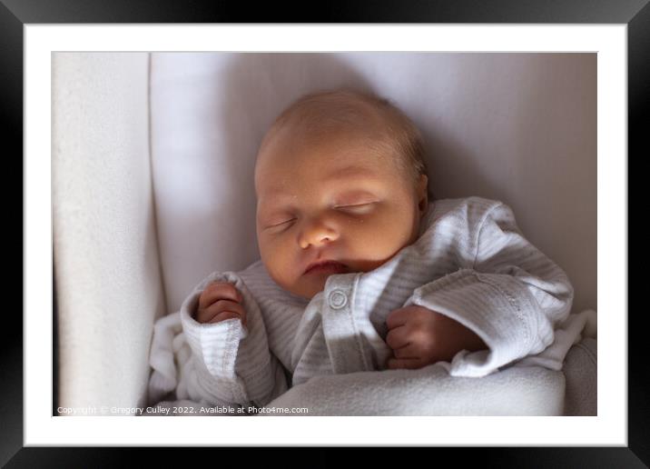 Newborn baby sleeping in moses basket Framed Mounted Print by Gregory Culley