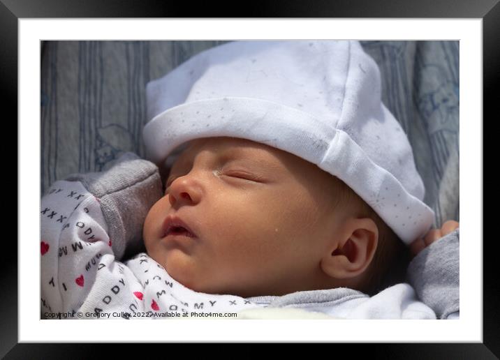 Sleeping newborn baby wearing sleepsuit and hat Framed Mounted Print by Gregory Culley
