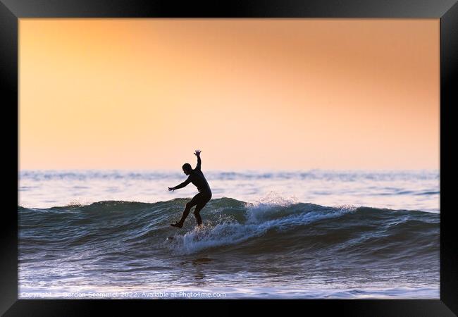 An acrobatic surfer riding a wave in Fistral Bay i Framed Print by Gordon Scammell