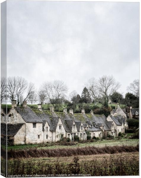 A View Of A Row of Historic Quintessential Cotswold Cottages In Bibury Canvas Print by Peter Greenway