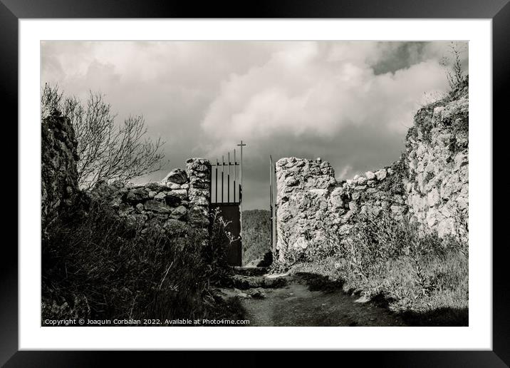 Scary entrance to an old stone cemetery with an iron gate. Framed Mounted Print by Joaquin Corbalan