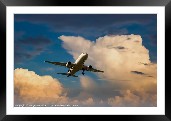 Passenger commercial aircraft flying on a dramatic sky background. Framed Mounted Print by Sergey Fedoskin