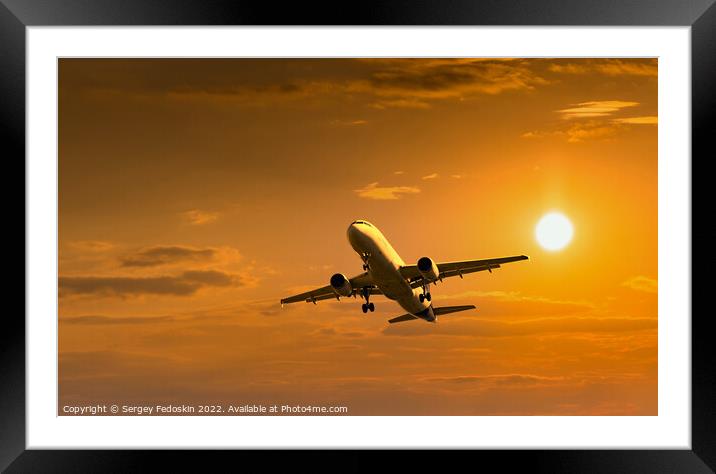 Passenger commercial aircraft flying under the clouds in sunset light. Framed Mounted Print by Sergey Fedoskin