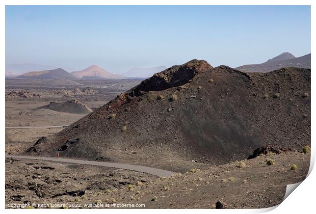 Lone figure walking in the Timanfaya National Park Print by Keith Bowser