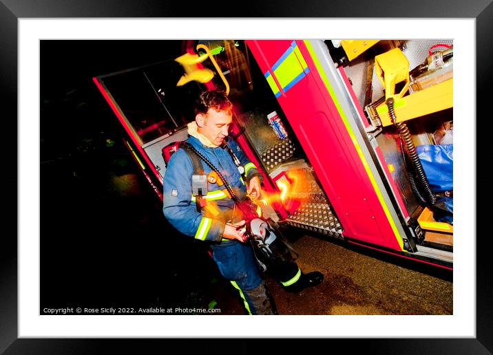 Firefighter in breathing apparatus and fire appliance with blurred lights at a fire Framed Mounted Print by Rose Sicily