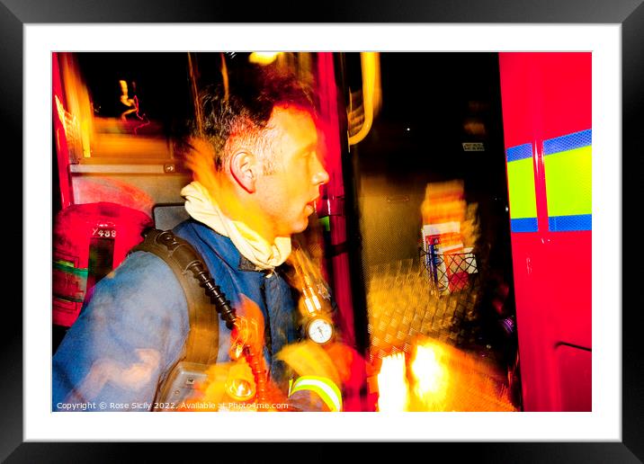 Firefighter in breathing apparatus and fire appliance with blurred lights at a fire Framed Mounted Print by Rose Sicily