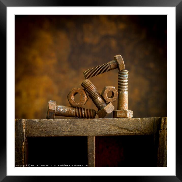 Rusty bolt on a wooden surafce Framed Mounted Print by Bernard Jaubert