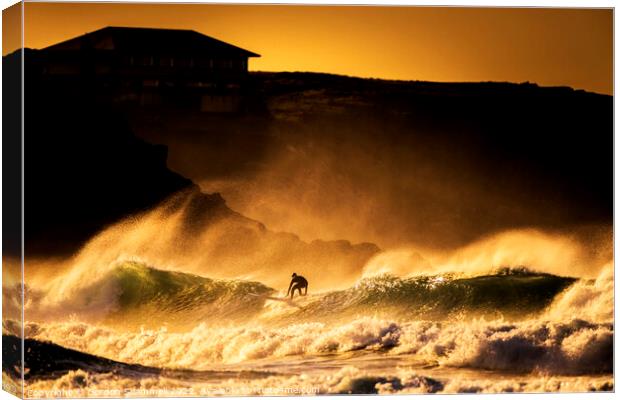 Surfing in wild seas during a golden sunset at Fis Canvas Print by Gordon Scammell
