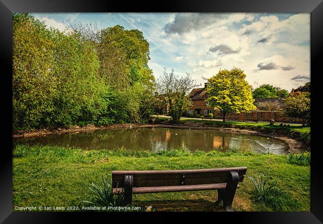 A Seat By The Village Pond Framed Print by Ian Lewis
