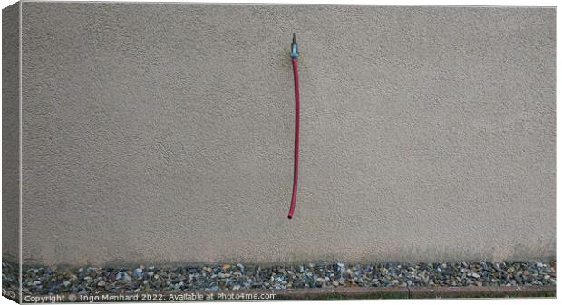 Closeup shot of a grey wall with a water tap and a hanging red hose Canvas Print by Ingo Menhard
