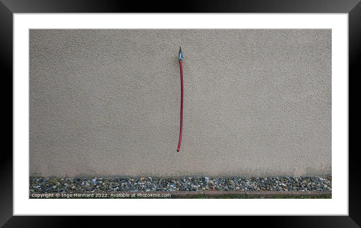 Closeup shot of a grey wall with a water tap and a hanging red hose Framed Mounted Print by Ingo Menhard