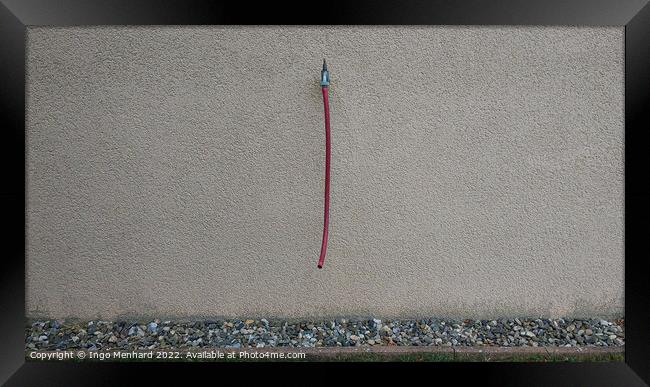 Closeup shot of a grey wall with a water tap and a hanging red hose Framed Print by Ingo Menhard