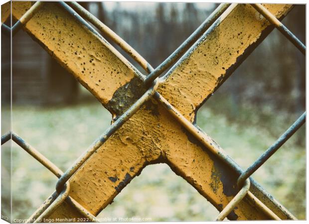 Old and weathered yellow-painted metal fence Canvas Print by Ingo Menhard