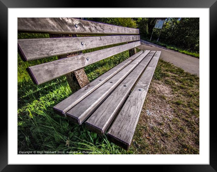 Closeup shot of a wooden bench near a road Framed Mounted Print by Ingo Menhard