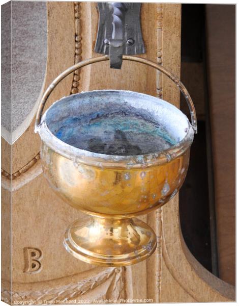 A vertical shot of an old golden goblet hung from a metal hook in the church Canvas Print by Ingo Menhard