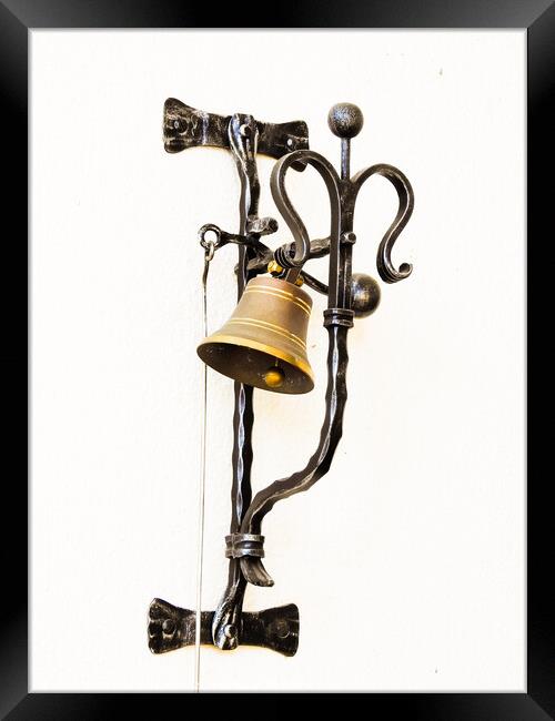 A vertical shot of a bell hung on the forged metal isolated on white background Framed Print by Ingo Menhard