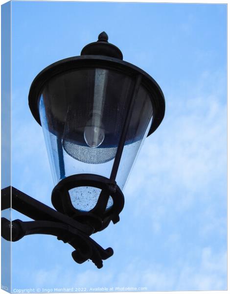 A vertical closeup shot of a street lamp against a cloudy sky Canvas Print by Ingo Menhard