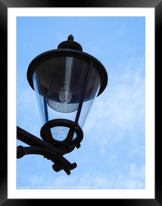 A vertical closeup shot of a street lamp against a cloudy sky Framed Mounted Print by Ingo Menhard