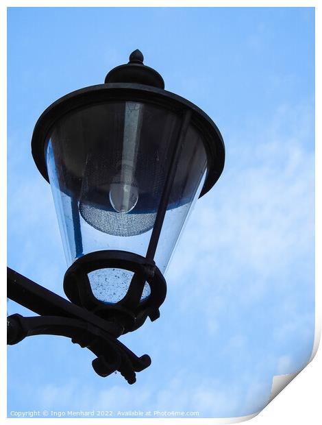 A vertical closeup shot of a street lamp against a cloudy sky Print by Ingo Menhard