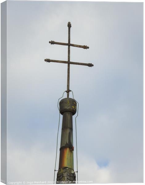 A vertical shot of a metallic cross on a cloudy sky background Canvas Print by Ingo Menhard