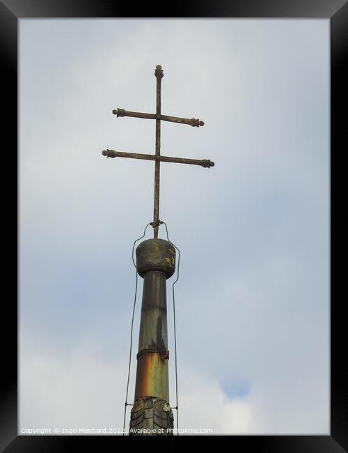 A vertical shot of a metallic cross on a cloudy sky background Framed Print by Ingo Menhard