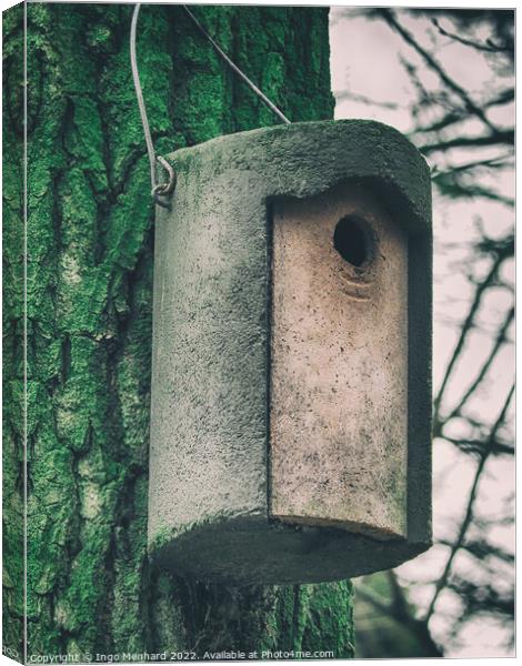 Vertical shot of a cylindrical concrete nesting box hanging from a tree Canvas Print by Ingo Menhard